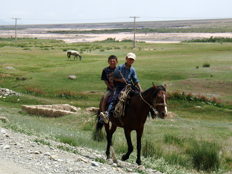 zwei kirgisische Jungen auf einem Pferd
